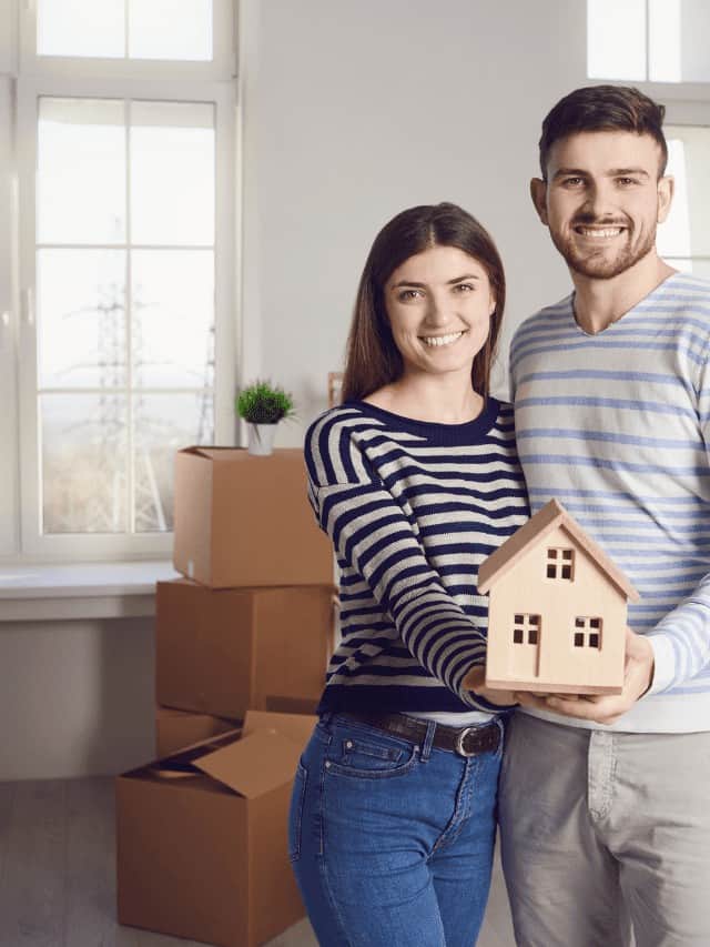 Couple Holding A Model Of The House Stock