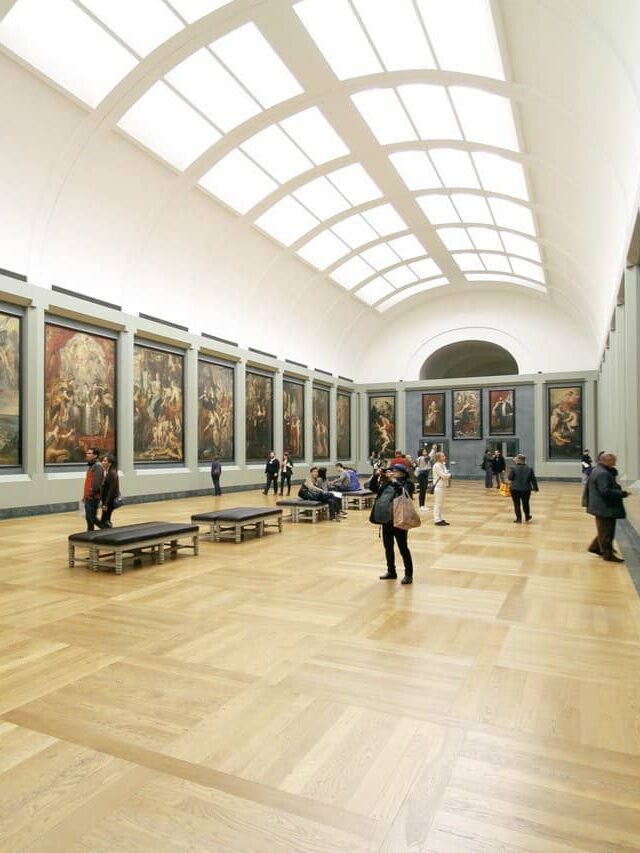 Museum Full of Paintings With Many People Stock