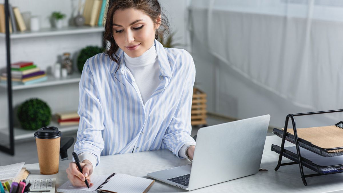 Woman Writing On A Notebook In An Office