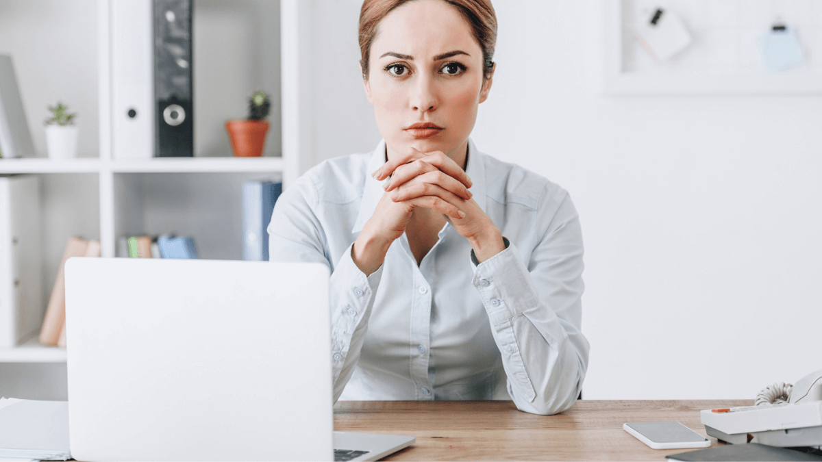 Woman looking serious sitting with laptop at workplace