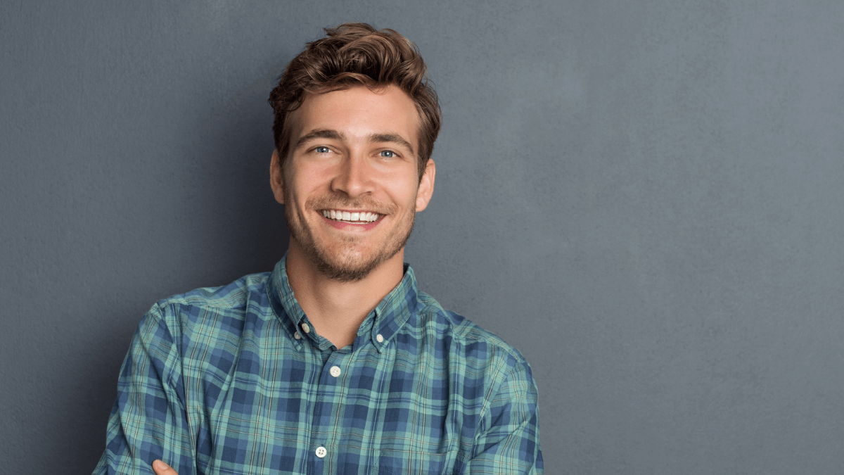Man Smiling Happy Standing Besides Wall MSN