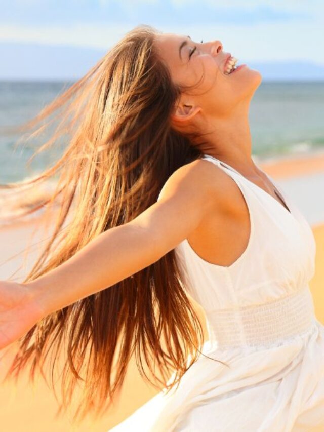 Happy Woman At The Beach With Arms Wide Spread