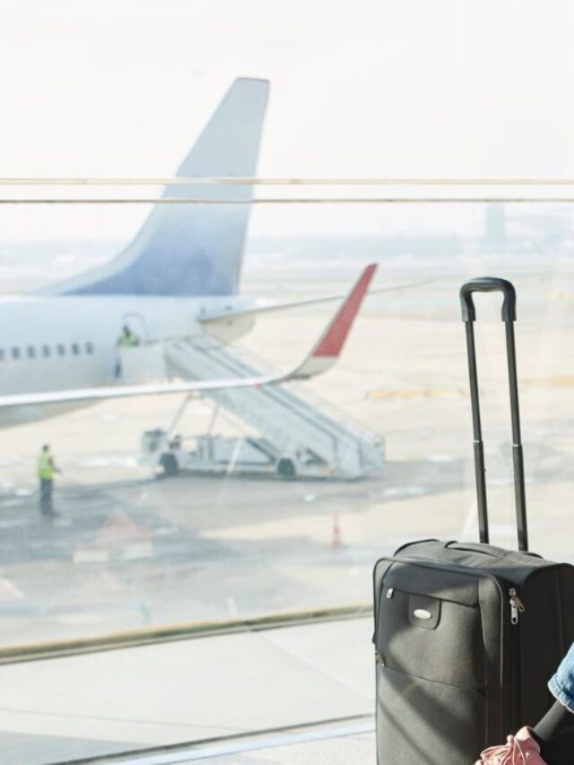 Woman Sitting In An Airport With A Luggage Waiting For Her Flight