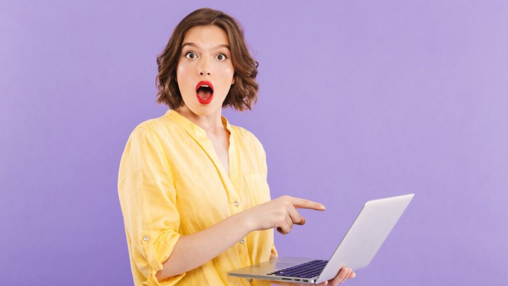 Short Haired Woman Pointing At Laptop Screen Shocked