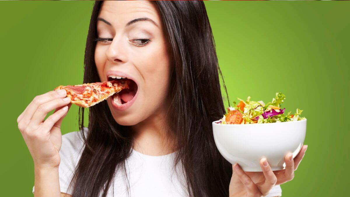 Woman-eating-pizza-and-bowl-of-salad-MSN