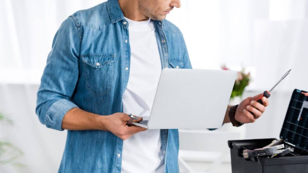 Man Holding Laptop And Repair Tools MSN