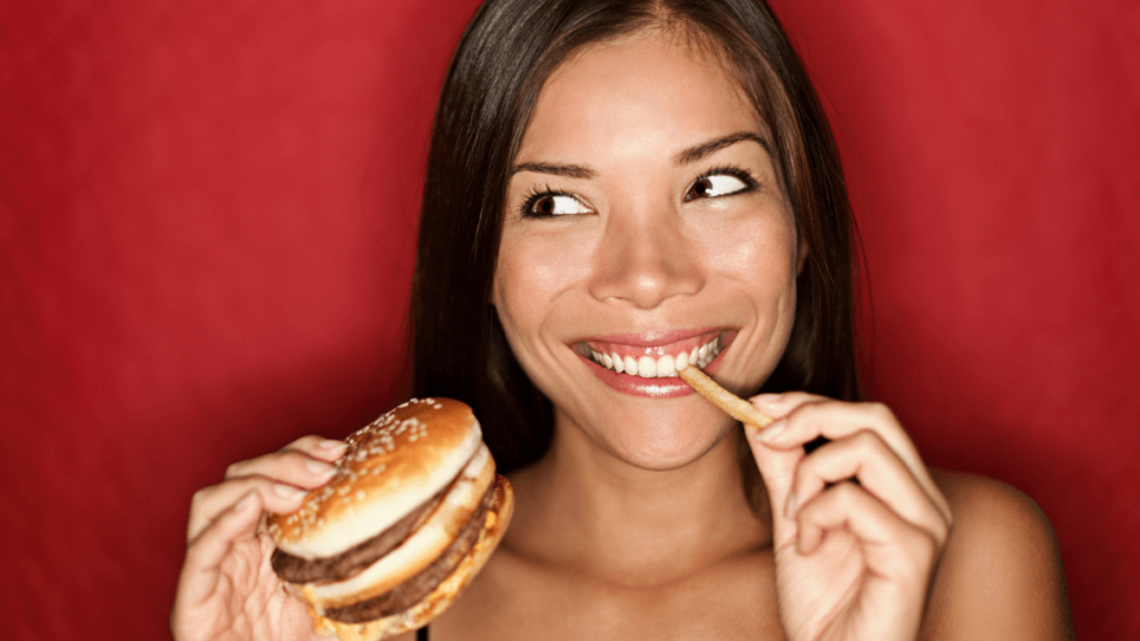 Woman Eating Food, Hamburger and Fries Smiling MSN