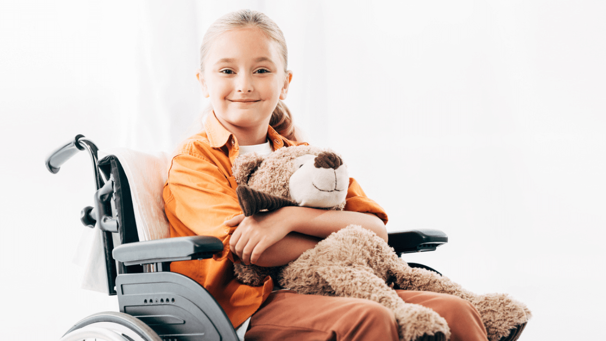 Child Sitting in Wheelchair Holding Teddy Bear Smiling MSN