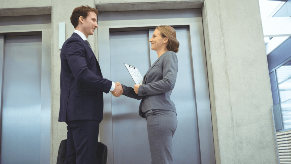 Man and Woman Shaking Hands in Front of Elevator MSN