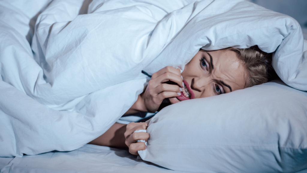 Scared woman under blanket - MSN