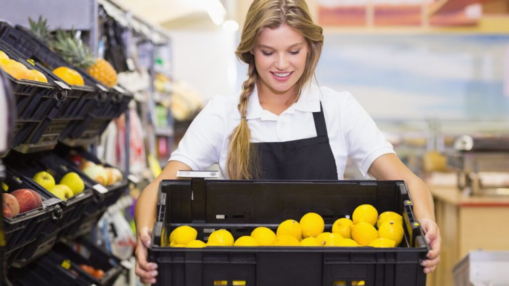 Young Woman Holding A Box Of Lemons At A Grocery