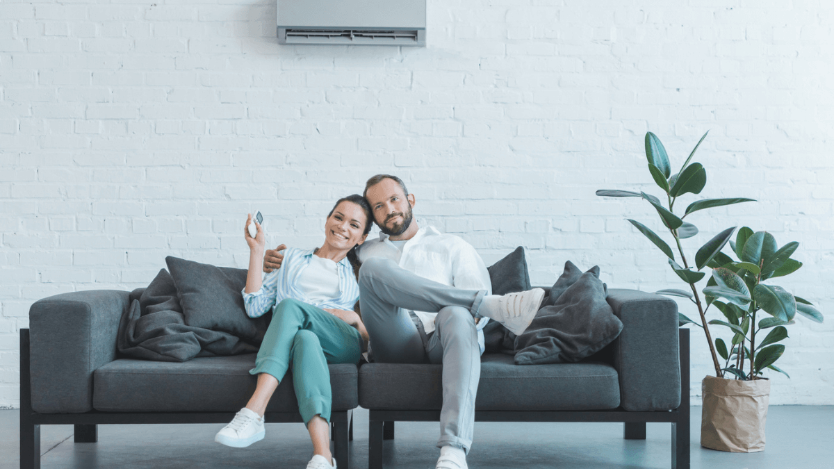 Couple Man and Woman Sitting on Couch in Living Room Home House with Air Conditioning MSN