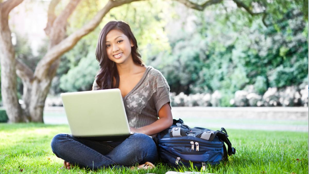 Female Student Sitting With Laptop On Campus Grounds MSN