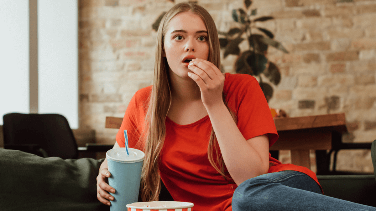 Woman Eating Popcorn Watching a Movie and Looking Chill MSN