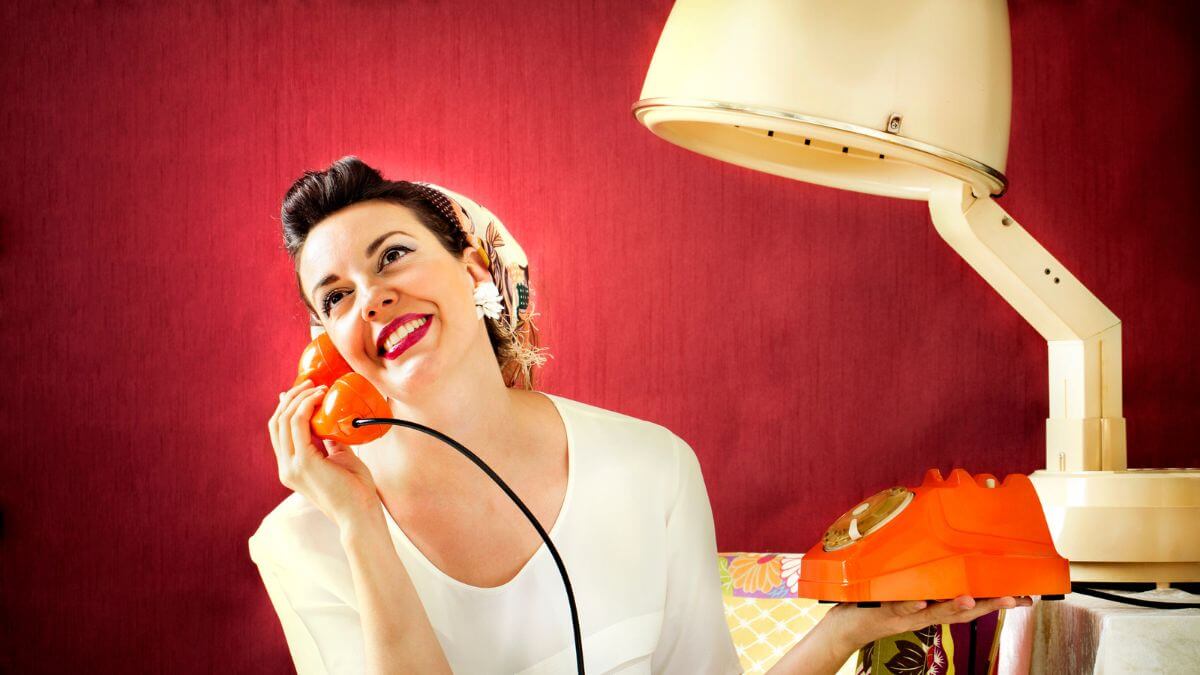 woman smiling using old landline phone calling MSN