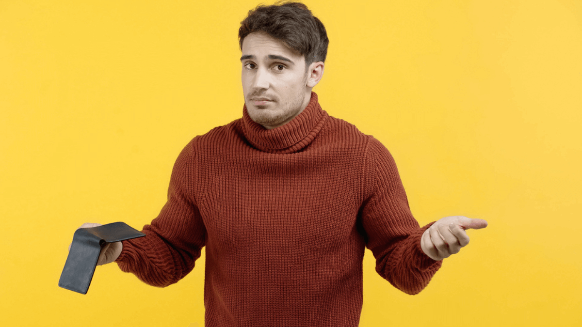 Confused man holding empty wallet - MSN