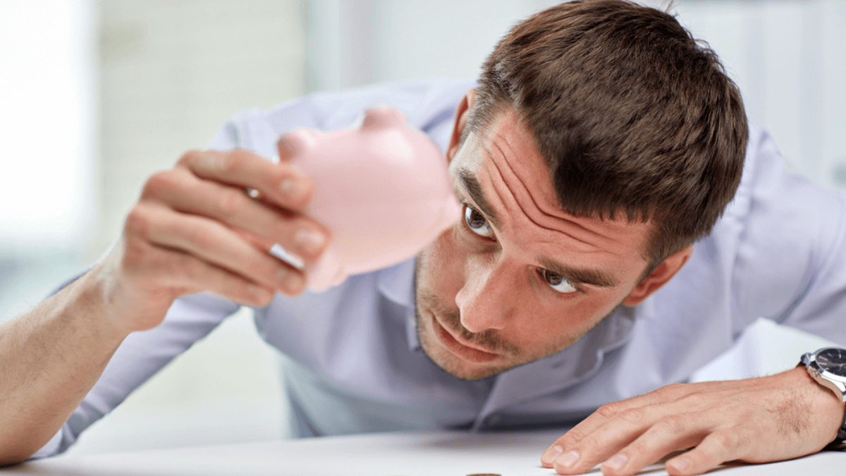 Man getting coins from piggy bank - MSN