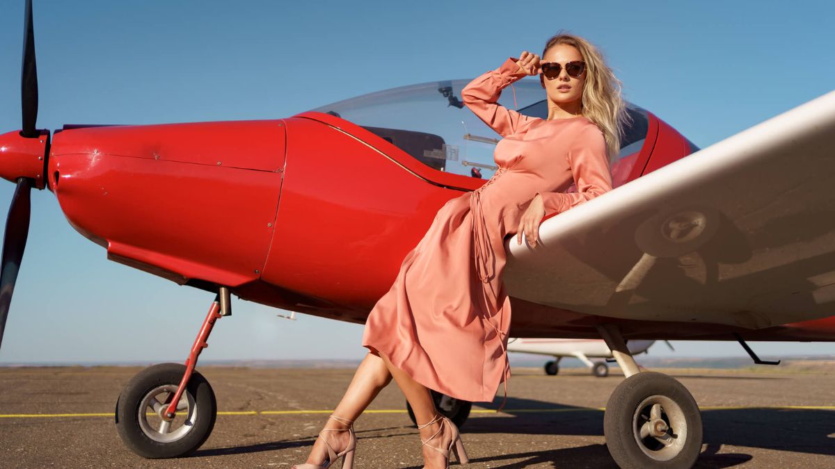 Woman In Pink Dress Posing Next To Airplane MSN