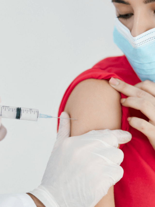 Doctor in medical mask injecting into the arm