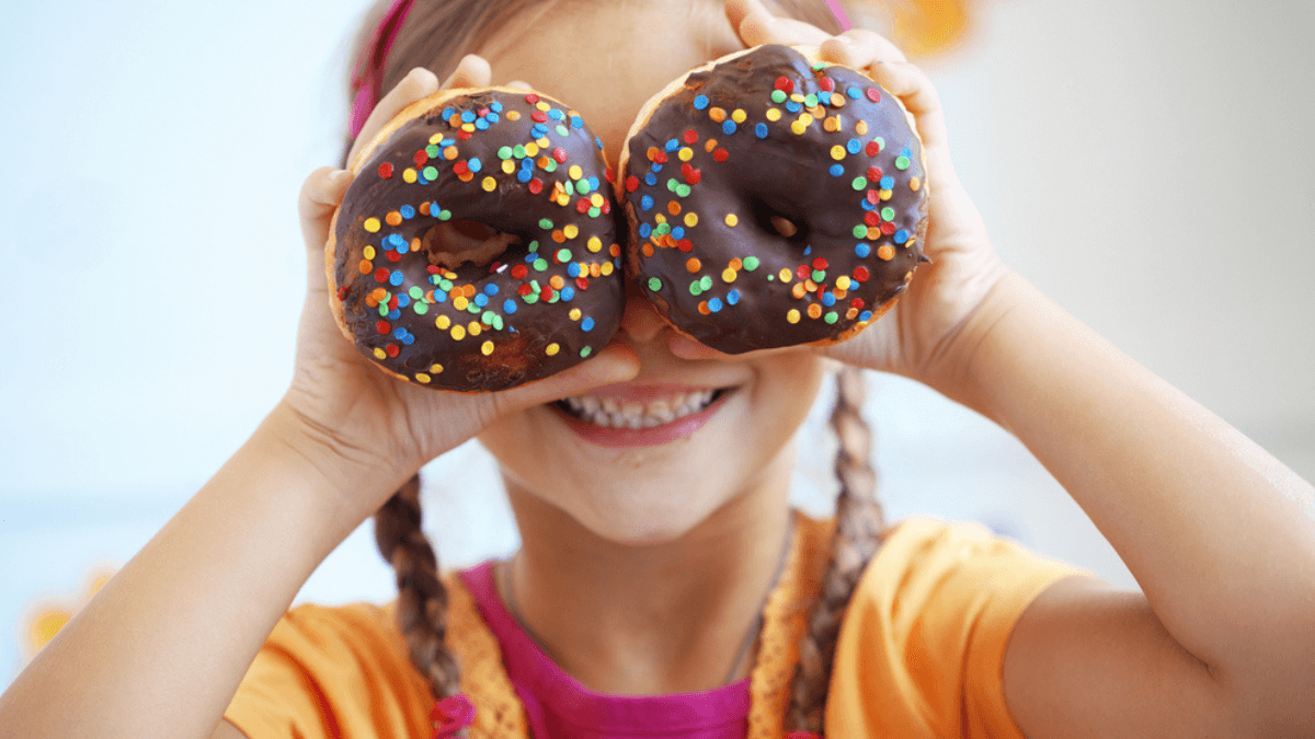 Little girl holding two donuts MSN