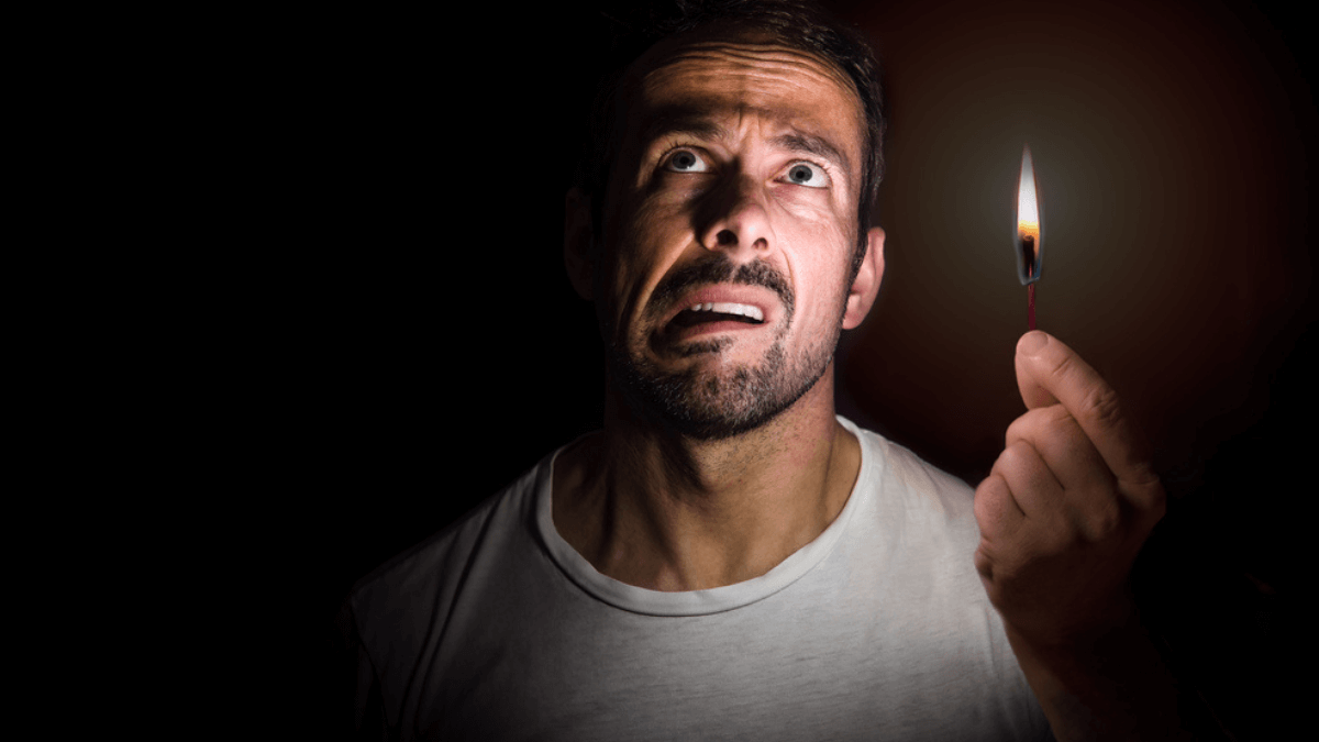 Worried man holding match stick during blackout MSN