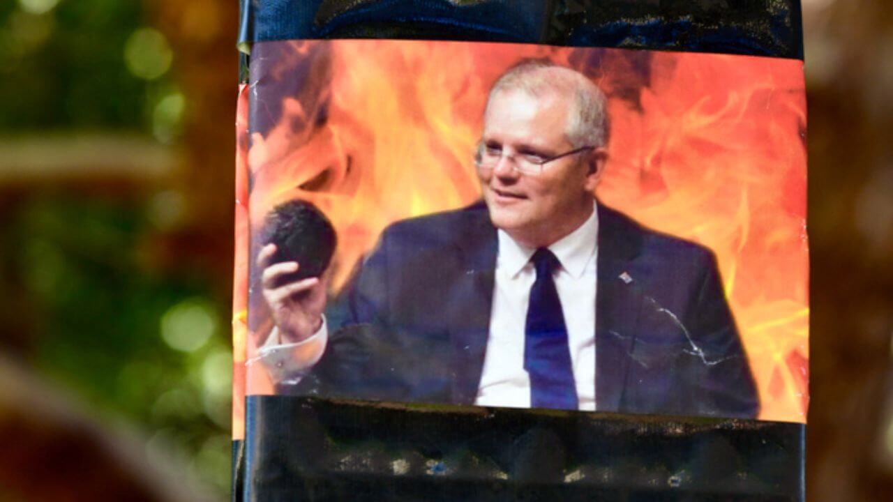Australian Prime Minister Scott Morrison on a placard criticizing fossil fuels at a Climate Change Rally