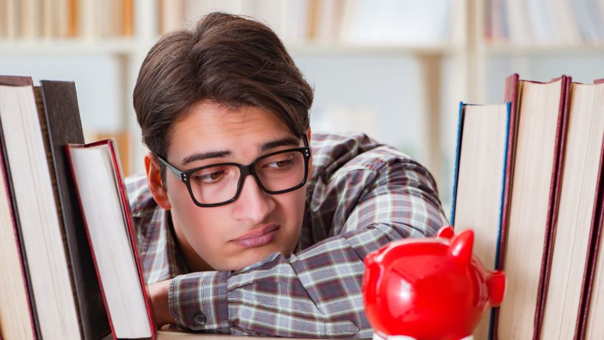 Man looking sadly at his piggy bank MSN