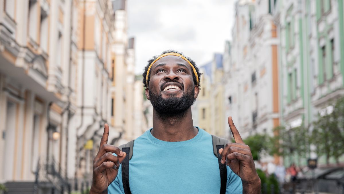 Grateful man pointing his two pointing fingers on the sky MSN