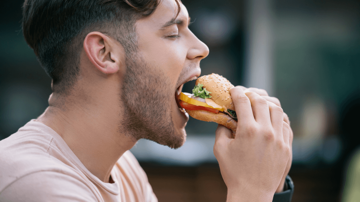 Man eating cheeseburger at one of the cheapest fast food chains MSN