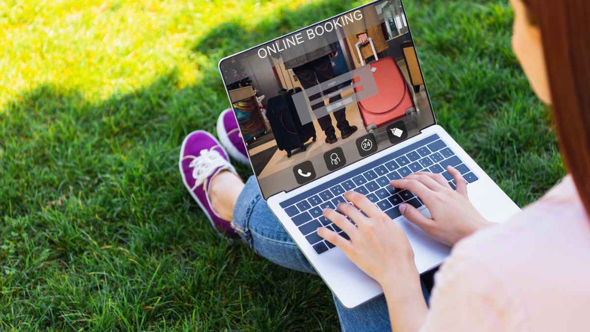 A woman sitting on grass using a laptop MSN.