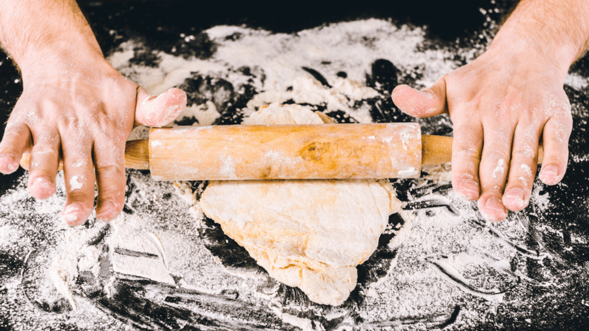 Hands forming dough with rolling pin MSN