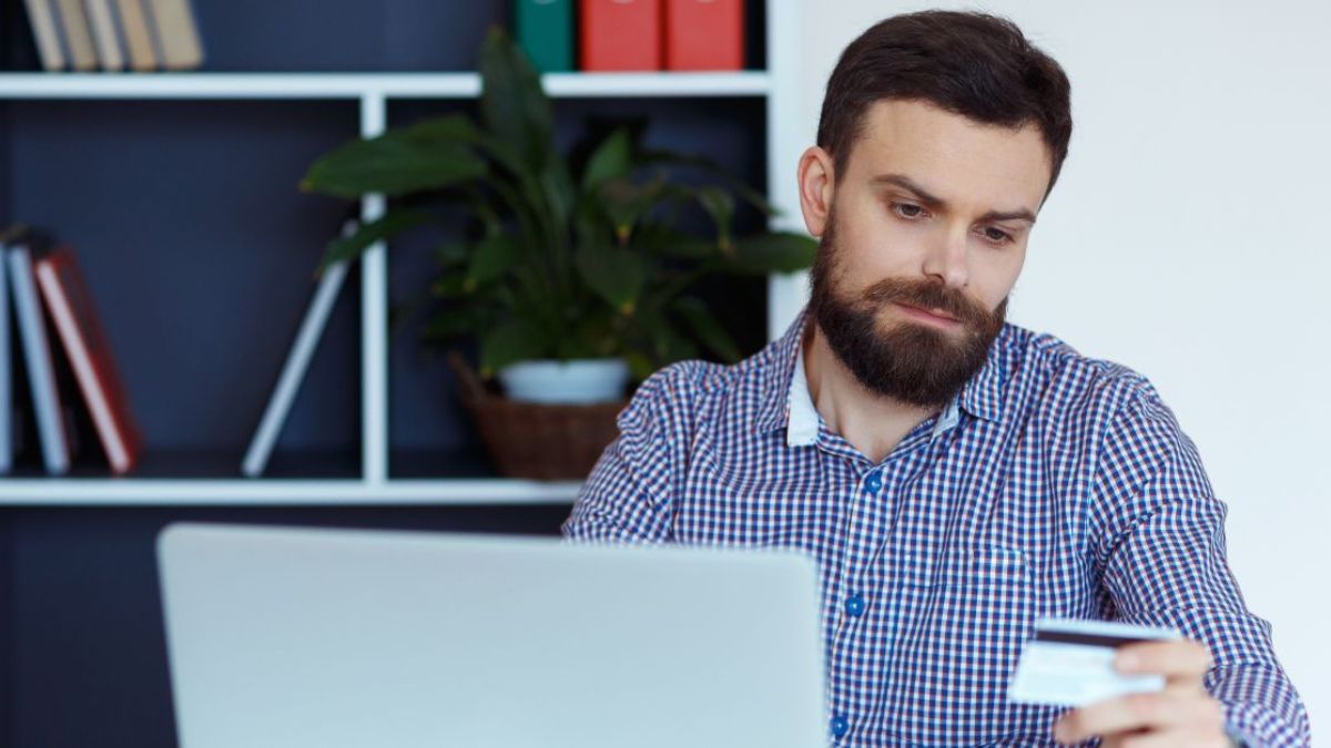 Man looking sadly at his credit card MSN