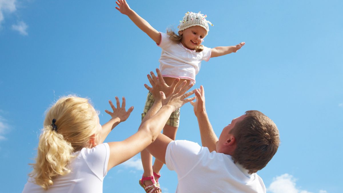 Parents playfully thorwing their daughter in air MSN