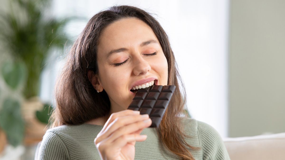 Woman deliciously eating a bar of dark chocolate MSN
