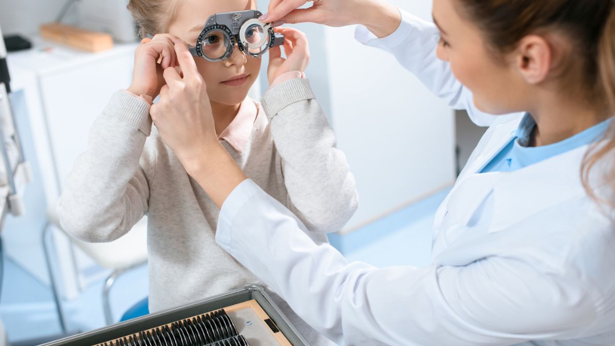 Optician measuring the little girl's eye grade MSN
