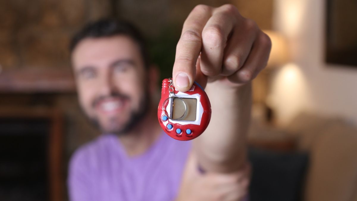 Smiling man holding a tamagotchi MSN