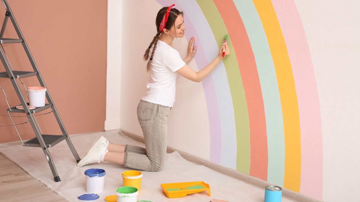 Woman painting a rainbow on the wall MSN