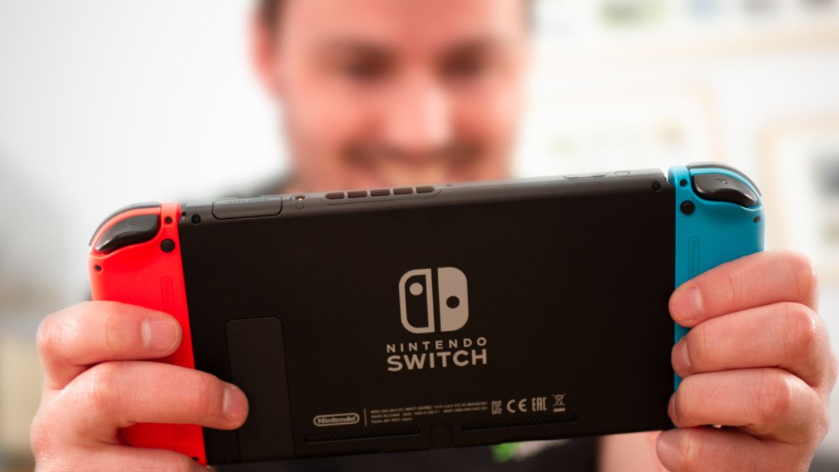Young man happily playing with his Nintendo console MSN