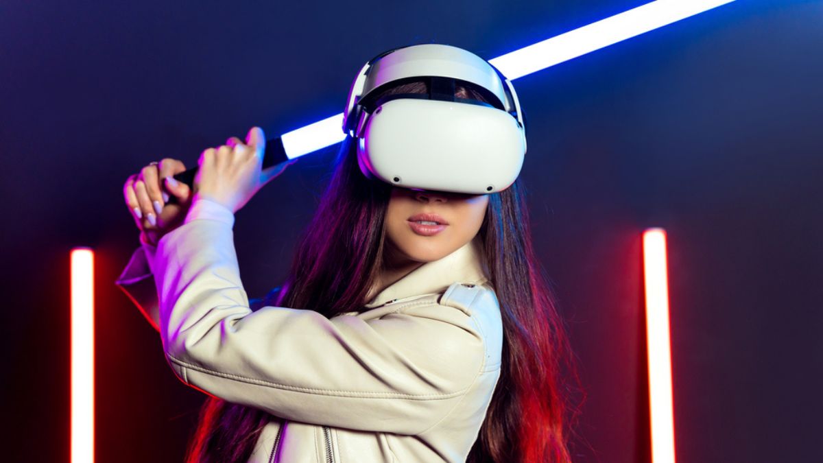 Young woman playing with lightsaber and VR headset MSN