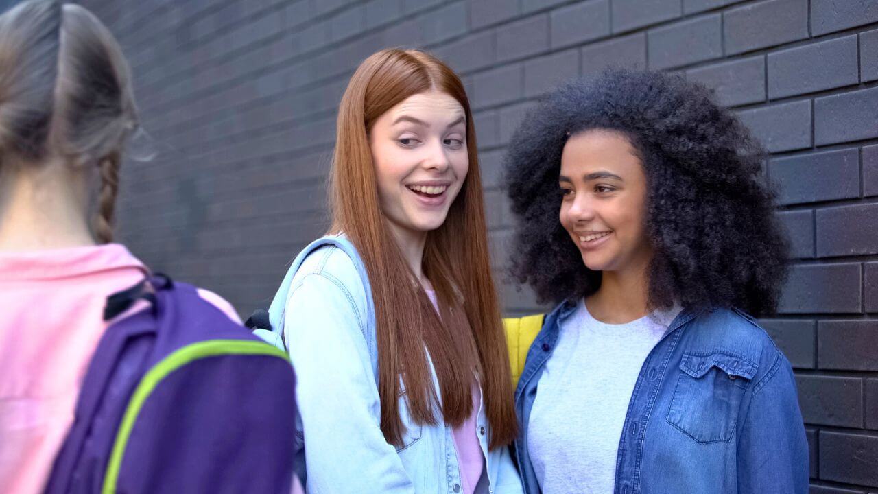 Female Teenagers Laughing At The New Student