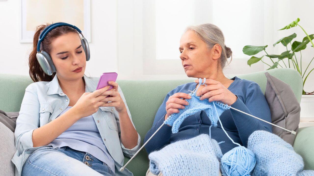 Millenials Daughter Listens to Music and Boomer Mom Knitting