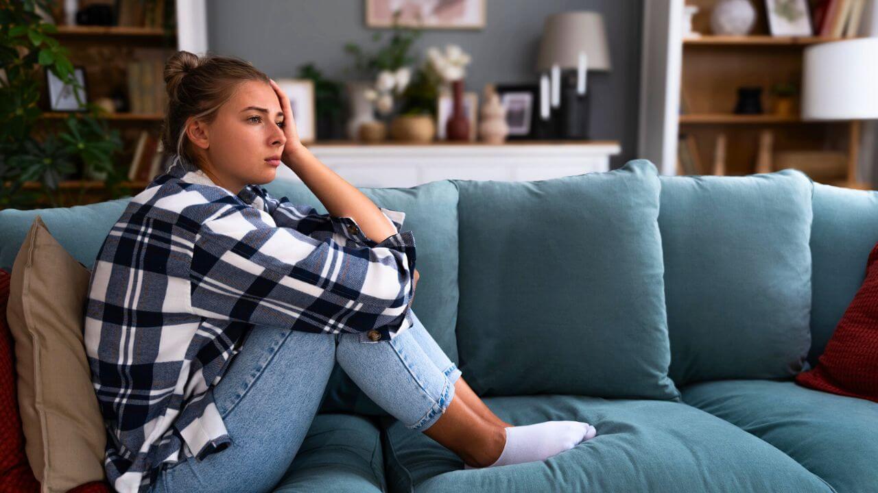 Young Depressed Woman Sitting Alone at Home