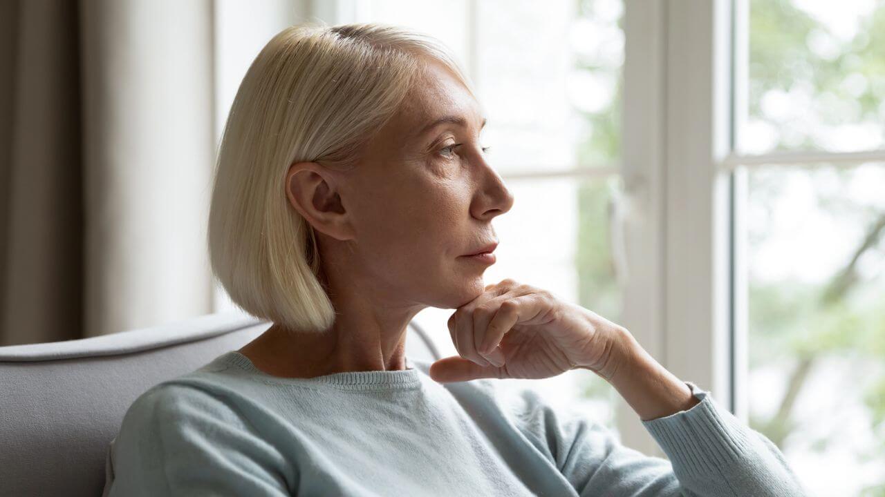 Pensive Mature Woman Look in Distance Thinking at Home