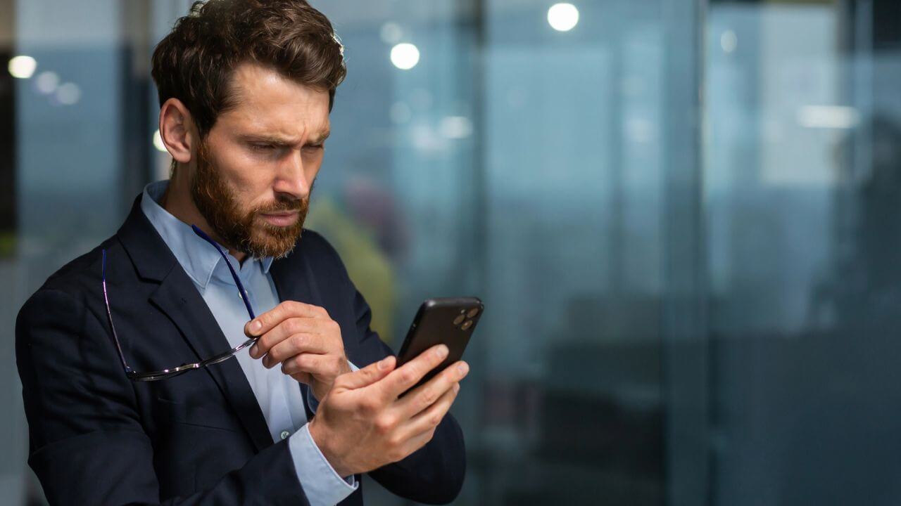 Upset Businessman Reading Message Phone Notification